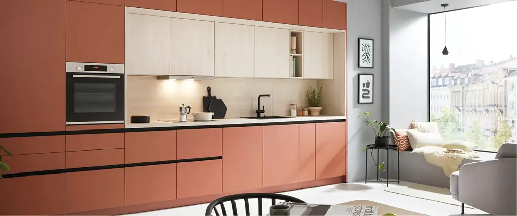 Moderne Einbauküche mit terrakottafarbenen Fronten, hellen Holzoberschränken und schwarzer Arbeitsplatte. Zeitloses Küchendesign mit klaren Linien, integrierten Geräten und stilvoller Beleuchtung in offenem Wohnraum.